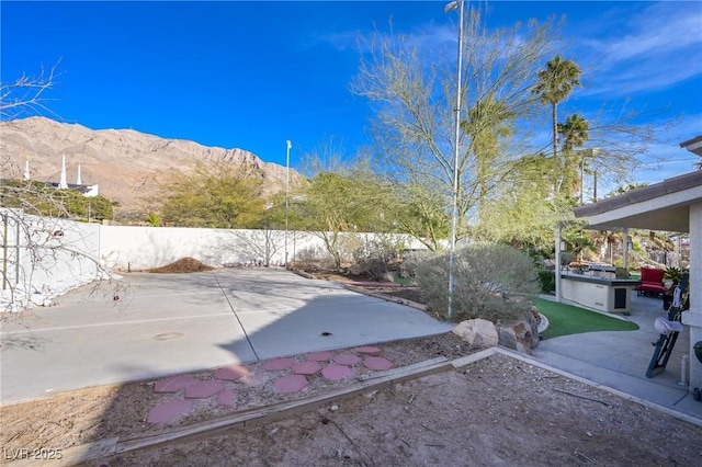 view of patio / terrace featuring a fenced backyard and a mountain view