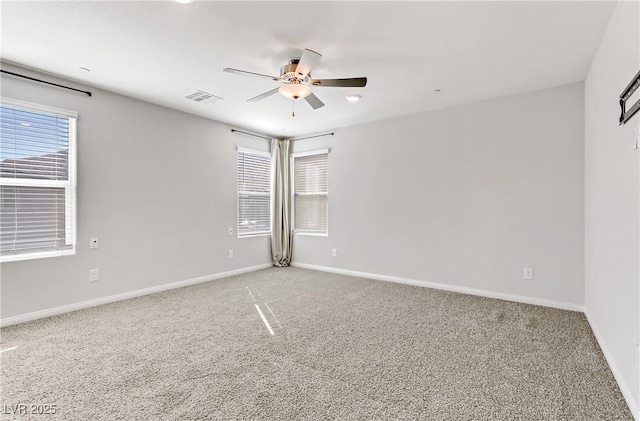 unfurnished room with visible vents, baseboards, a ceiling fan, and carpet flooring