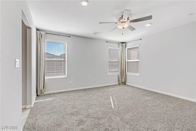 empty room featuring visible vents, ceiling fan, light carpet, and baseboards