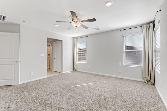 empty room featuring light carpet, visible vents, and baseboards