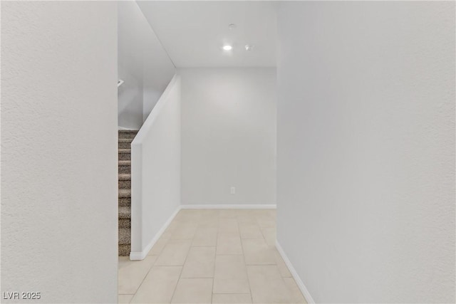 corridor featuring stairway and baseboards