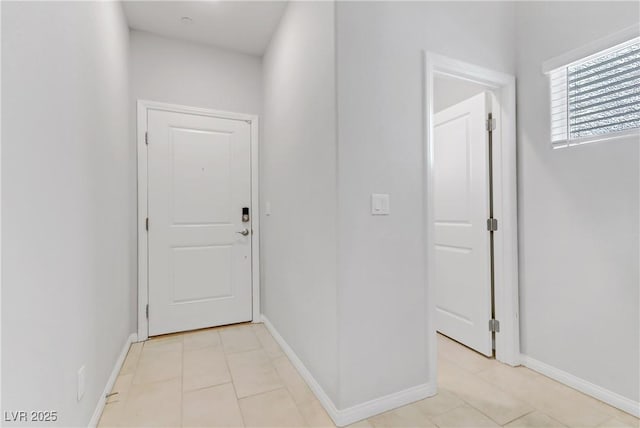 interior space with light tile patterned floors and baseboards