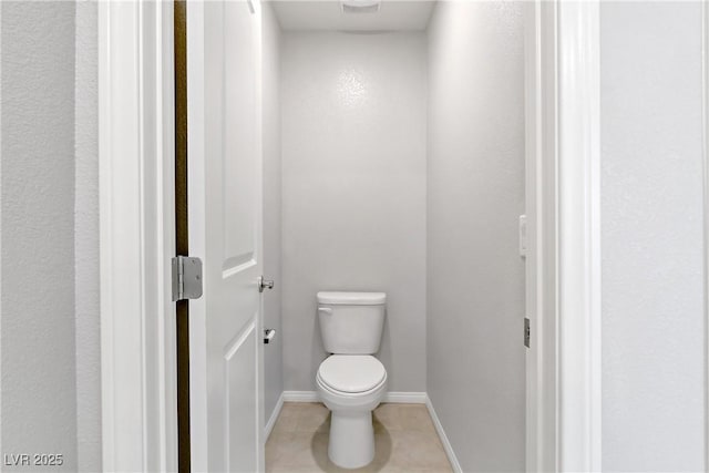 bathroom with toilet, baseboards, and tile patterned floors