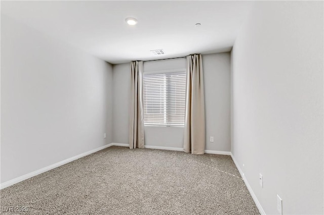 unfurnished room with carpet floors, visible vents, and baseboards