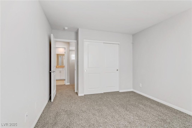 unfurnished bedroom with carpet, a closet, and baseboards