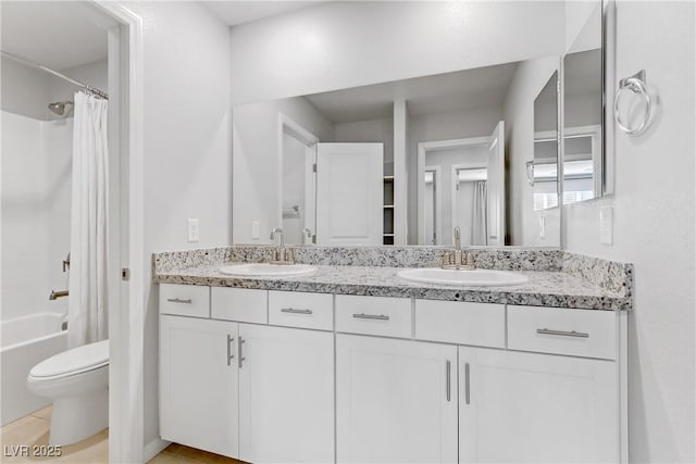 bathroom with double vanity, toilet, a sink, and shower / tub combo with curtain