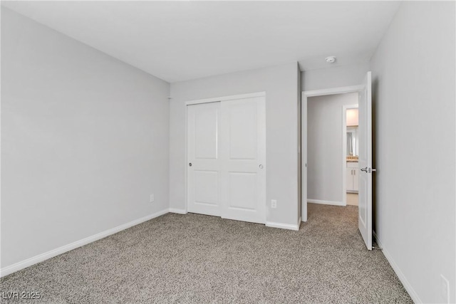 unfurnished bedroom featuring a closet, carpet flooring, and baseboards