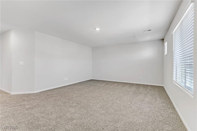 carpeted empty room with visible vents and baseboards