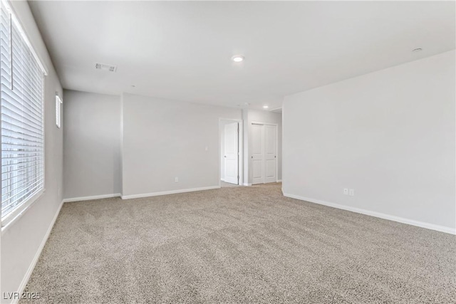 spare room featuring carpet floors, recessed lighting, visible vents, and baseboards