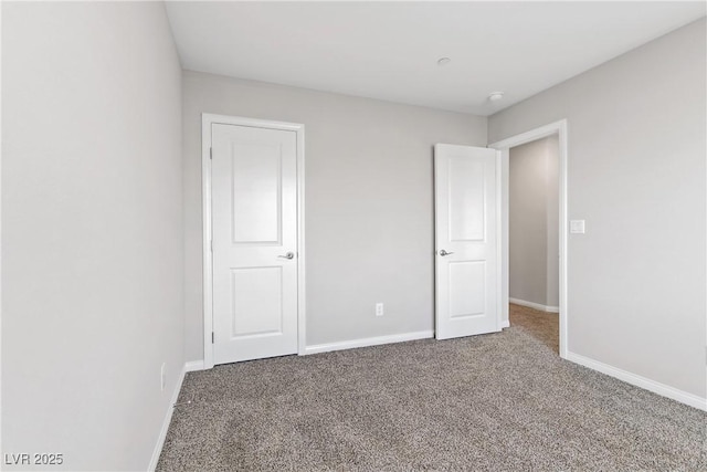 unfurnished bedroom with carpet flooring and baseboards