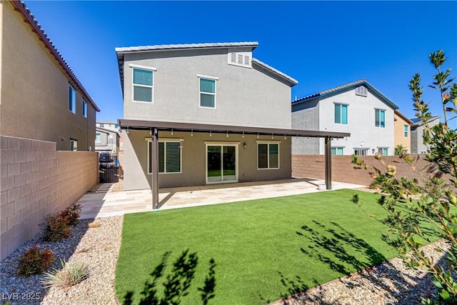 back of property featuring a yard, a fenced backyard, a patio, and stucco siding