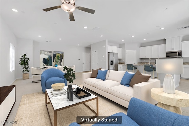 living area with visible vents, a ceiling fan, and recessed lighting