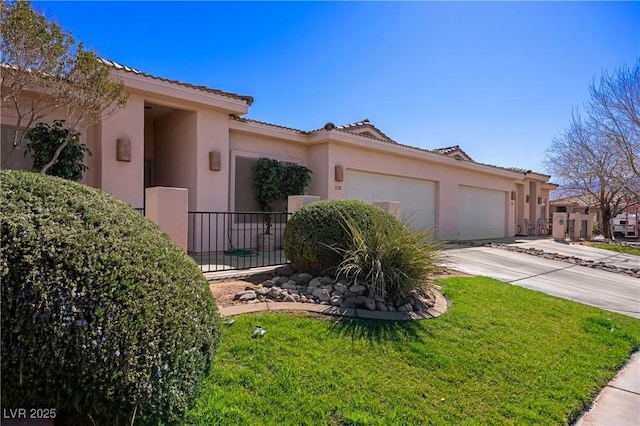 view of front of house featuring stucco siding, a front yard, fence, a garage, and driveway