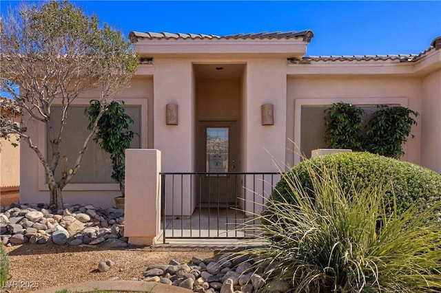 property entrance featuring an attached garage and stucco siding