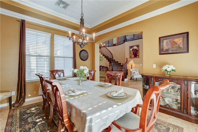 dining room featuring baseboards, visible vents, an inviting chandelier, stairs, and crown molding