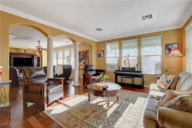 living room featuring decorative columns, visible vents, arched walkways, dark wood-style flooring, and crown molding