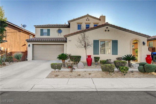 mediterranean / spanish house featuring concrete driveway, an attached garage, a tile roof, and stucco siding