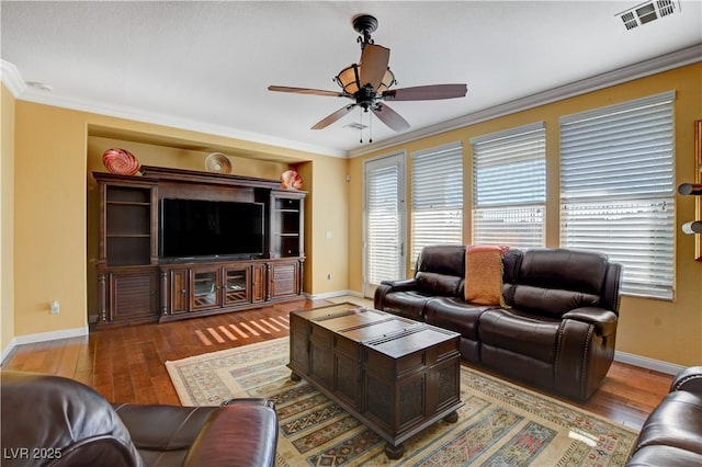 living area featuring ceiling fan, hardwood / wood-style floors, visible vents, and crown molding