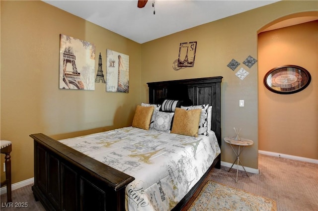 bedroom with arched walkways, carpet flooring, a ceiling fan, and baseboards