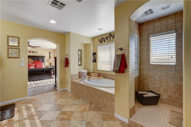 ensuite bathroom with a garden tub, connected bathroom, visible vents, and a ceiling fan