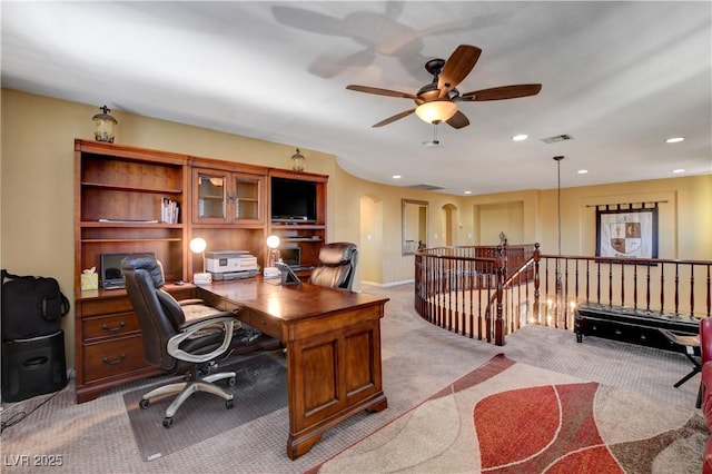 office featuring arched walkways, recessed lighting, visible vents, light carpet, and ceiling fan