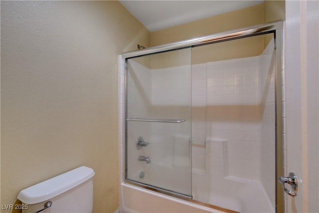 full bathroom with bath / shower combo with glass door and toilet