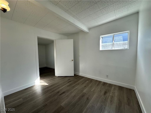 empty room with dark wood-style flooring and baseboards