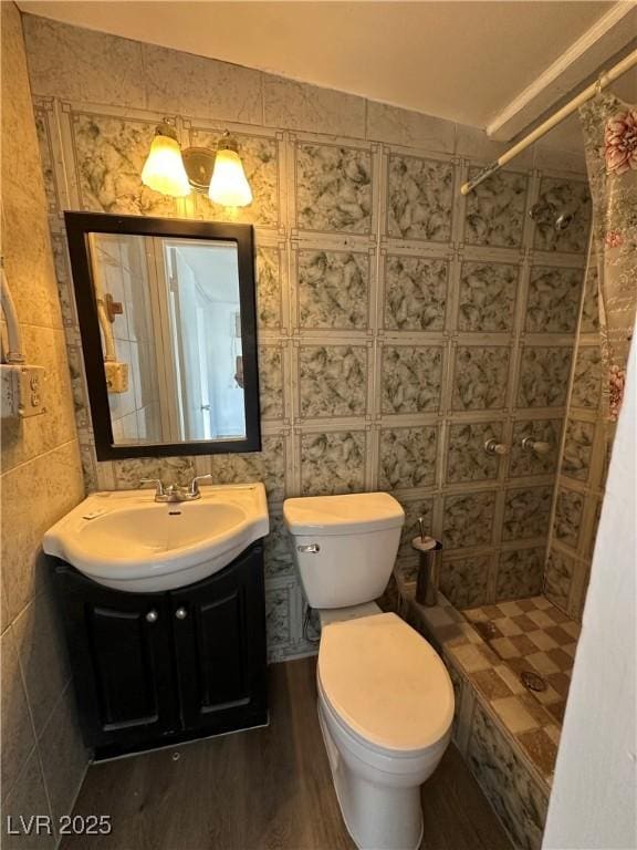 bathroom featuring toilet, a stall shower, wood finished floors, and vanity