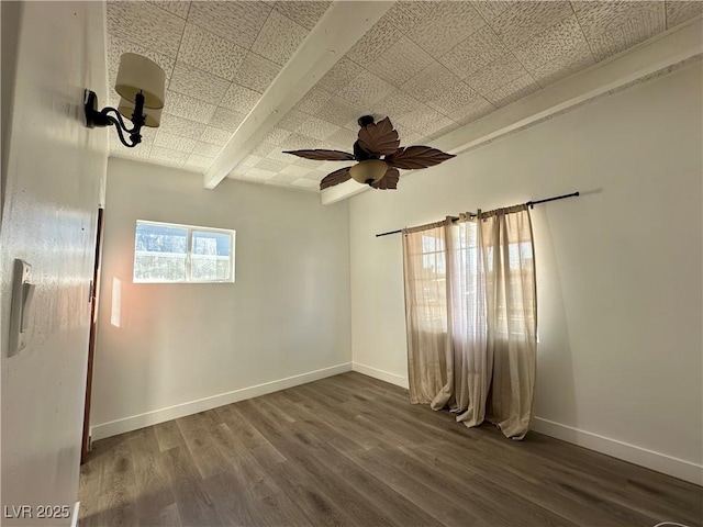 unfurnished room featuring dark wood-style flooring, ceiling fan, and baseboards