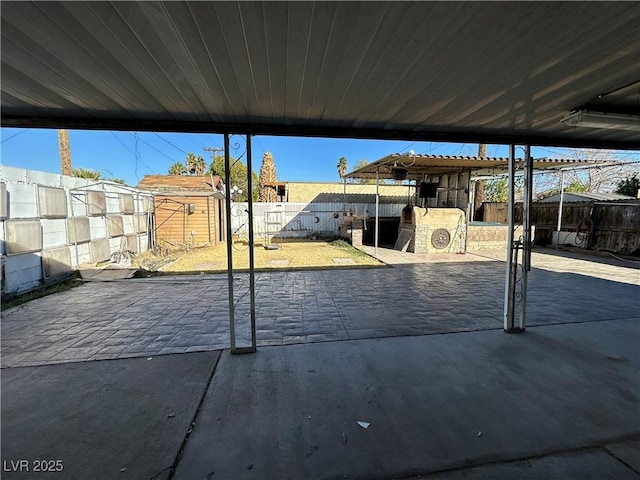 view of patio / terrace with a fenced backyard, a storage unit, and an outbuilding