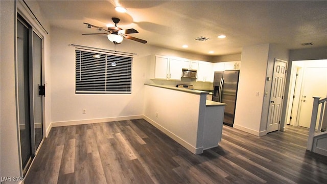 kitchen featuring stainless steel fridge, baseboards, dark wood-style floors, light countertops, and white cabinetry