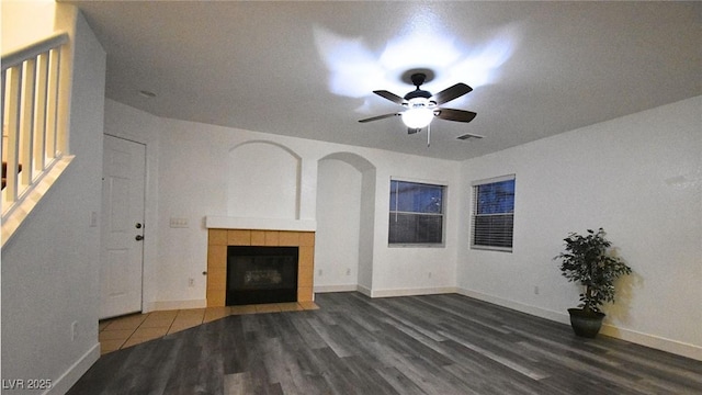 unfurnished living room featuring baseboards, a fireplace, visible vents, and dark wood-type flooring