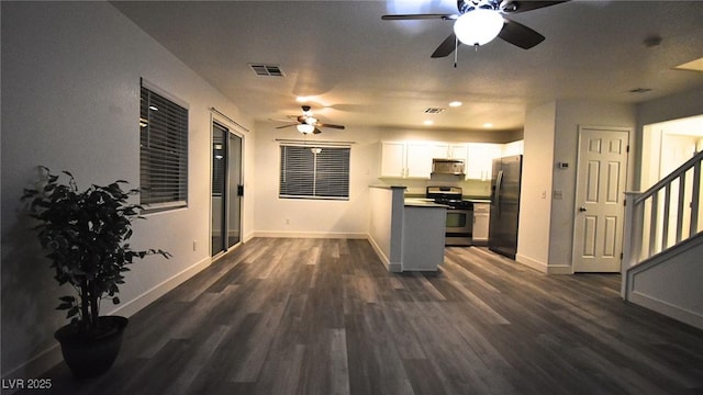 kitchen with dark wood-style floors, appliances with stainless steel finishes, visible vents, and white cabinets