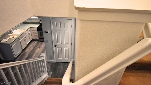 stairway featuring wood finished floors and a textured wall