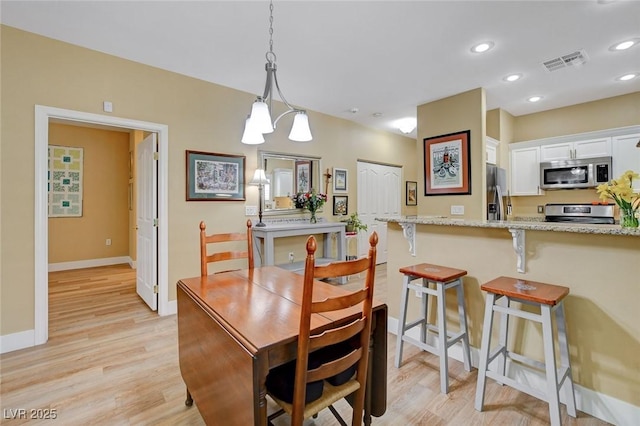 dining area with light wood-style floors, recessed lighting, visible vents, and baseboards