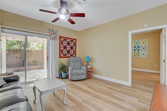 living room with light wood finished floors, visible vents, and baseboards