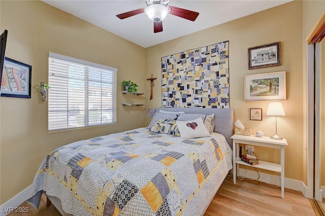 bedroom featuring a ceiling fan, baseboards, and wood finished floors