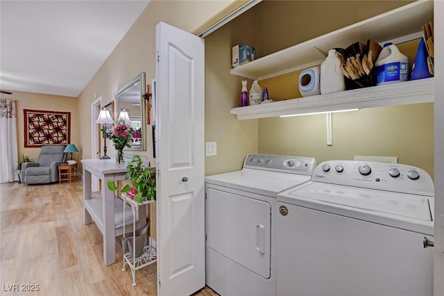 washroom featuring washing machine and dryer, laundry area, and light wood finished floors