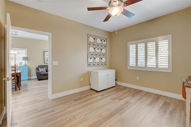 unfurnished room with baseboards, ceiling fan, light wood-type flooring, and a healthy amount of sunlight