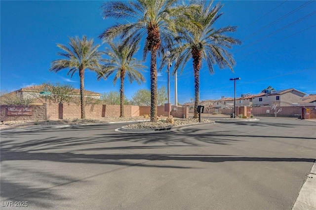 view of street featuring a residential view, a gate, a gated entry, and curbs