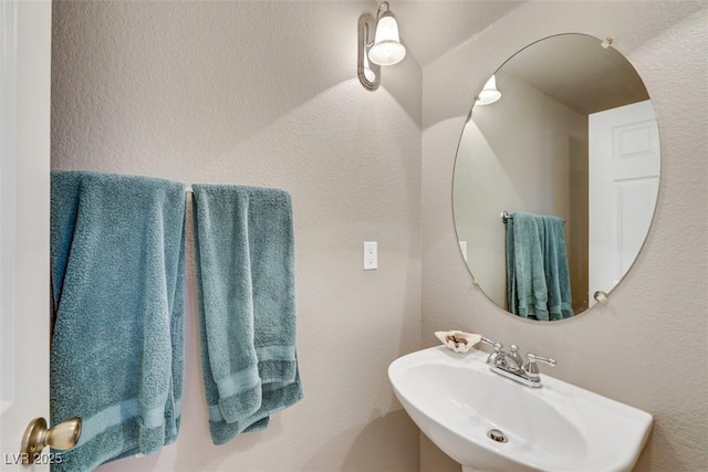 bathroom with a textured wall and a sink