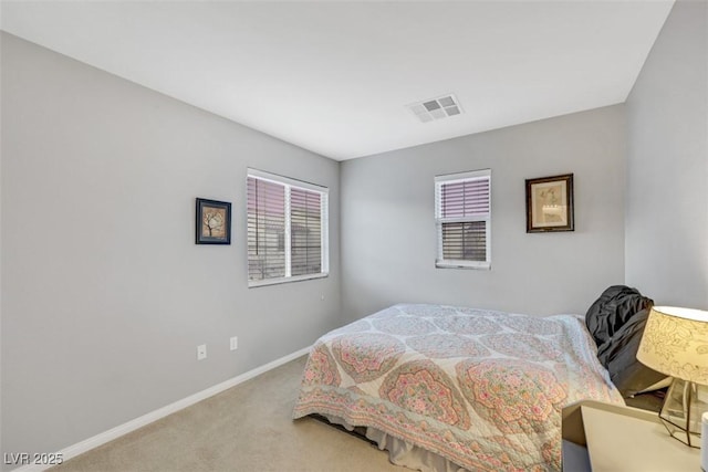 carpeted bedroom with visible vents and baseboards