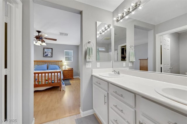 bathroom with double vanity, visible vents, a sink, and ensuite bathroom