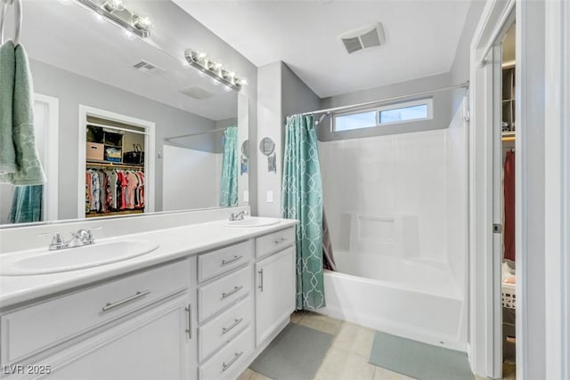 full bathroom with a spacious closet, visible vents, shower / bath combo with shower curtain, and a sink