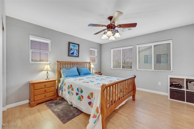 bedroom with a ceiling fan, light wood-style flooring, and baseboards