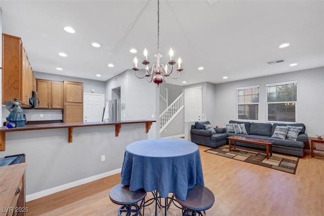 dining room with baseboards, visible vents, stairs, light wood-type flooring, and recessed lighting