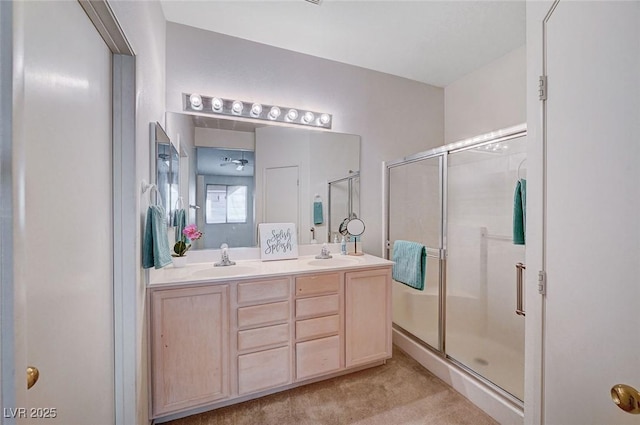 full bath with double vanity, a stall shower, and a sink