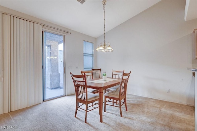 dining room with an inviting chandelier, vaulted ceiling, and light colored carpet