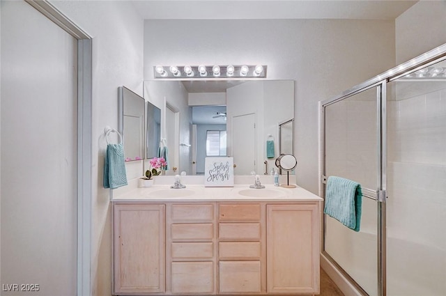 full bath with double vanity, a stall shower, and a sink