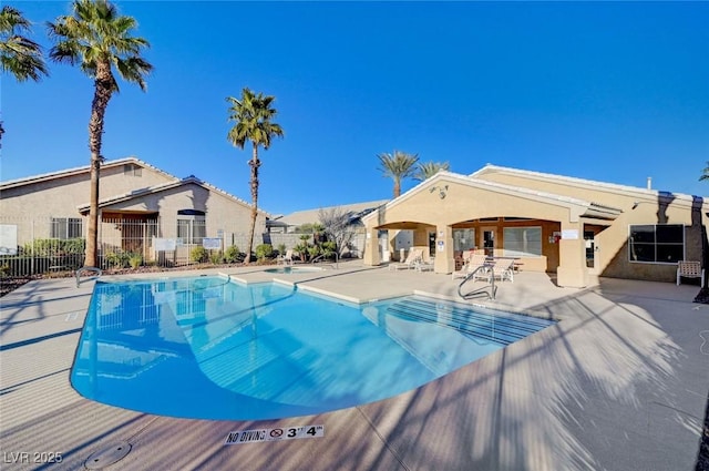 community pool with fence and a patio